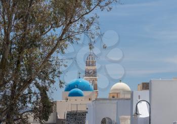 Skyline with clock tower and domes in village of Fira on Santorini