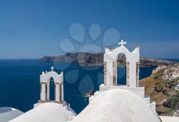 Traditional Greek Orthodox church with bell tower in village of Oia on Santorini