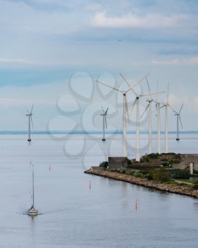 Multiple wind turbines generating electricity at entrance to Copenhagen harbor in Denmark