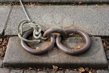 Two old iron rings and knotted rope used to moor a boat off Copenhagen canal