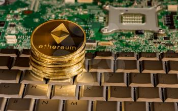 Ethereum coin on a keyboard with computer board to illustrate blockchain and cyber currency