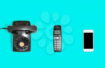 Three phones from rotary dial through wireless to modern smartphone