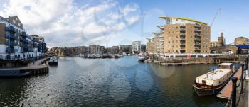 LONDON, UK - JANUARY 30, 2016: Panoramic photo of the apartment buildings and boats around Limehouse Basin Marina in Docklands, London, England