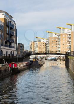 LONDON, UK - JANUARY 30, 2016: View from Limehouse Cut to the apartment buildings around Limehouse Basin Marina in Docklands, London, England