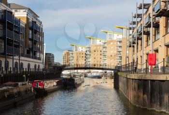 LONDON, UK - JANUARY 30, 2016: View from Limehouse Cut to the apartment buildings around Limehouse Basin Marina in Docklands, London, England