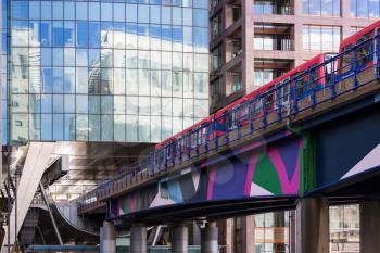 LONDON, UK - JANUARY 30, 2016: Docklands Light Railway or DLR train enters Heron Quay station in Canary Wharf, Docklands, London, England