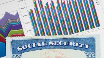 Social Security card in the USA laid on top of charts and graphs of budget in retirement