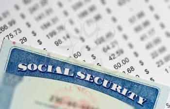 Social Security card in the USA laid on top of figures and calculation of budget in retirement
