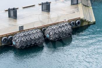 STAVANGER, NORWAY - SEPTEMBER 20, 2017: Tire filled rubber bumpers protect the dock in Stavanger Harbor in Norway