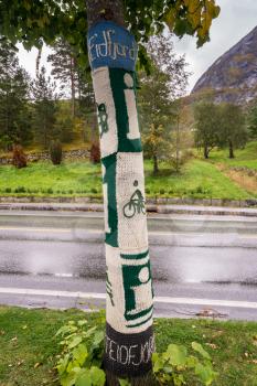 EIDFJORD, NORWAY - 21 SEPTEMBER 2017: Knitted woolen coverings on tree trunks in Eidfjord in Norway