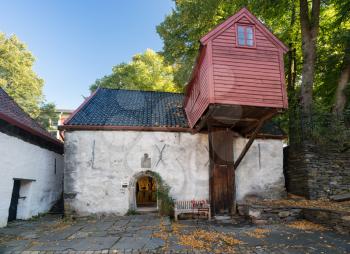 Stone cottage with overhanging warehouse in Bryggen district in the center of Bergen, Norway