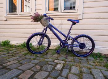 Painted purple or violet bicycle in the old town of Bergen in Norway