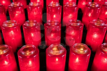 Pattern of votive candles in glass jars for prayer and remembrance in Catholic church