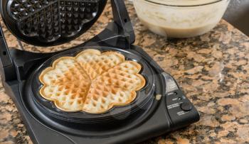 Norwegian heart shaped waffle maker on granite kitchen worktop