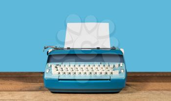 Modern electric typewriter on wooden desk background with copy space