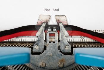 Macro detail of the ink ribbon and text of electric typewriter with words The End