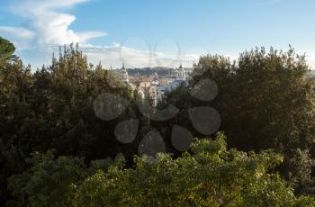 Domes of dueling churches in Piazza del Popolo behind trees in Rome
