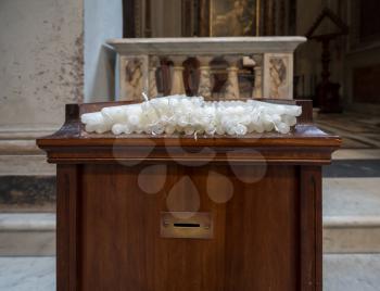 Stack of votive or prayer candles in a catholic church in Rome, Italy