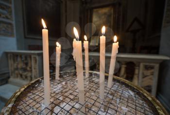 Lit votive or prayer candles in a catholic church in Rome, Italy
