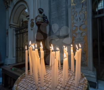 Lit votive or prayer candles in a catholic church in Rome, Italy