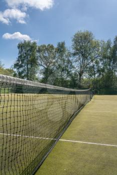 Close detail of the netting in a tennis net on outdoor artificial grass court