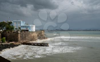 La Fortaleza castle and walls with rough seas in San Juan Puerto Rico with storm clouds