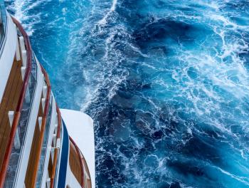 View down the floors of cruise ship at the powerful churning ocean behind the ship