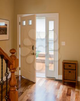 Open front door leading onto wood steps with lobby or hall with hardwood flooring
