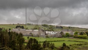 Storm clouds above the granite walls and buildings of HM Prison Dartmoor