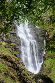 Upper flow of water into mid level pool at waterfall of Pistyll Rhaeadr falls in Wales