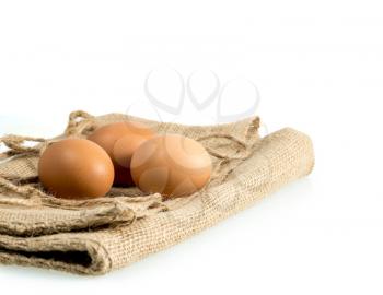 Easter background with brown organic eggs arranged on burlap sack and isolated against white background