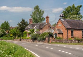 Delightful brick cottages and small church on roadside in Burlton, Shropshire
