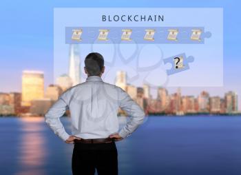 Blockchain schematic on glass panel with senior technology executive looking at the chart with New York city in background