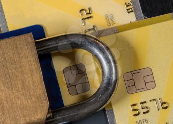 Brass padlock on credit cards with focus on electronic chip for security or credit lock