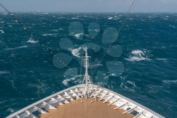 View from front at the rough seas and waves forward of bow of cruise ship
