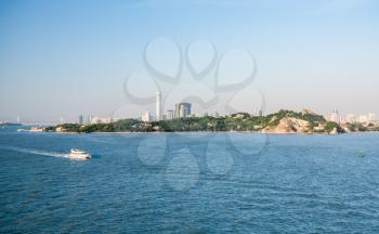 Ferry boat passes island of Gulangyu in foreground with background of Xiamen in China