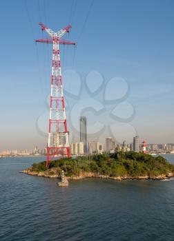 Tall electricity power tower on small island in harbor of Xiamen in China