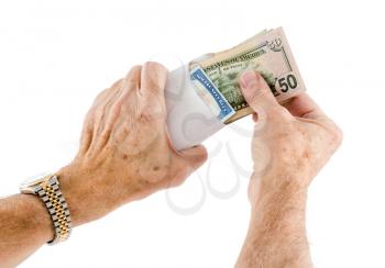 Stack of fifty US dollar bills being put in envelope with social security card by senior caucasian hands. Isolated against white background