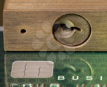 Brass padlock on business credit card with focus on the chip in the card