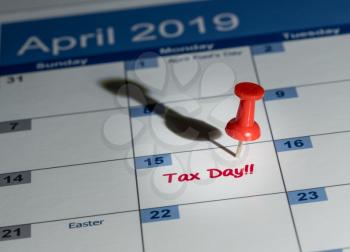 Tax day is April 15th for filing to IRS with red push pin in calendar for reminder