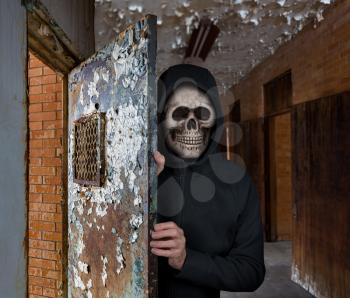 Halloween theme of man with skull welcoming visitors to haunted prison cell
