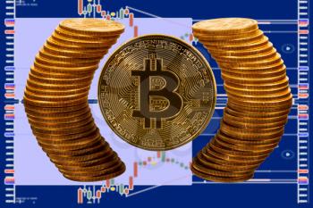 Single bitcoin coin with pure gold coins reflected in glass surface. Gives illusion of being surrounded by ring of gold with background of trading screen