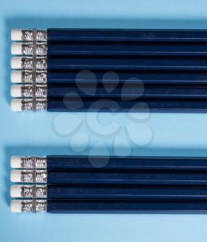 Row of new blue pencils lined up with erasers side by side. Copy space for message in gap