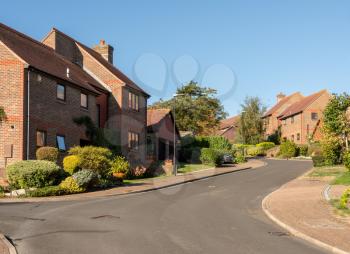 Street leading to a development of modern single family detached homes in the UK