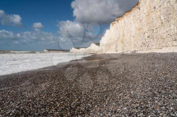 Low view of rocky beach on stormy day looking towards Seven Sisters at Birling Gap near Eastbourne