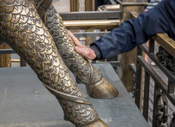 Rubbing leg of lion or dragon outside Queen of Heaven Palace for good luck