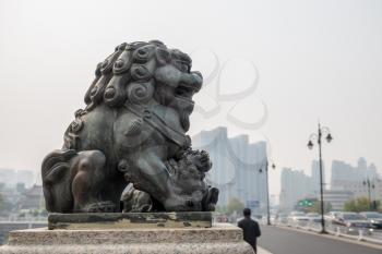 Detail of lion and cub carving on bridge in downtown Tianjin, China