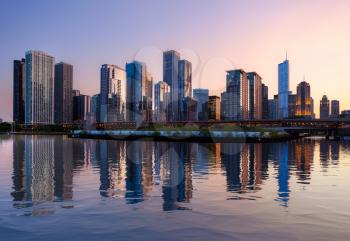 Sunset over the tall skyscrapers of Chicago from Navy Pier with artificial water reflection