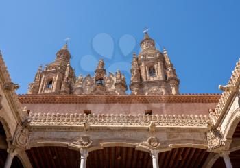 Ornate stone carvings on the Casa de la Conchas or shells around the courtyard with Clericia church in Salamanca