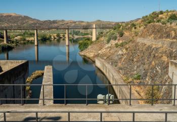 Barragem do Pocinho dam on the Douro river in Portugal as cruise boat waits by lock gates